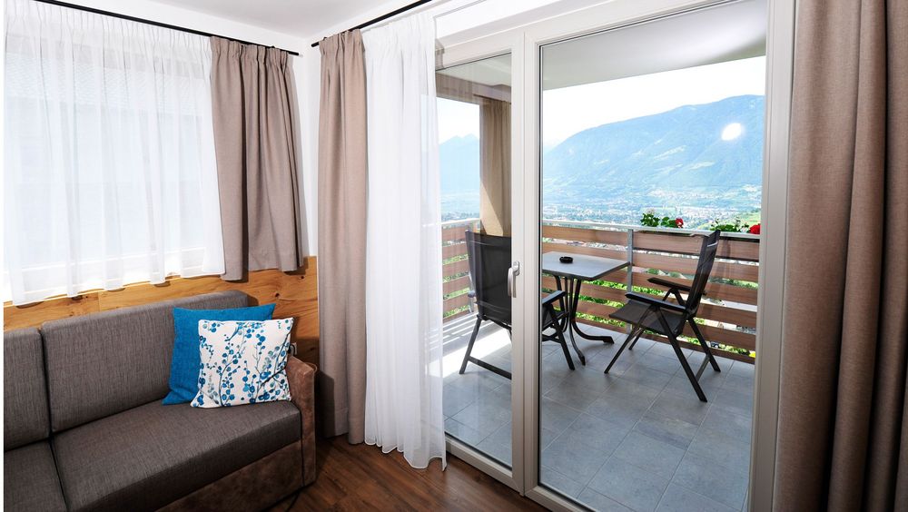Wohnzimmer mit Balkon und Bergblick bei Tageslicht