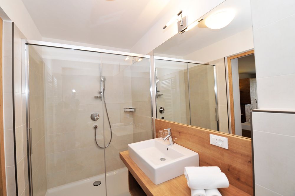 Moderne Badezimmer mit Dusche, Waschbecken und großem Spiegel