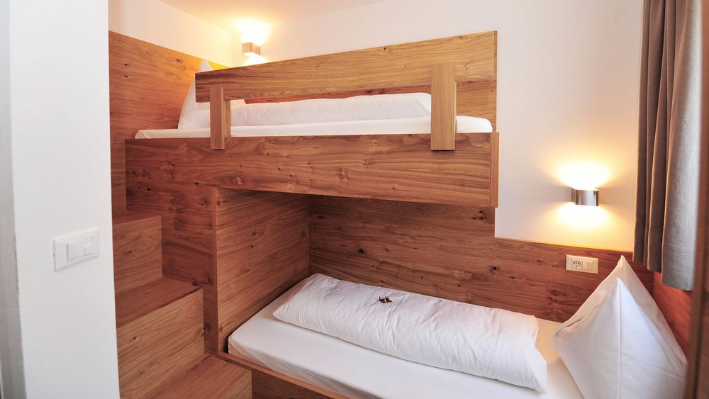 Zimmer mit Holz-Etagenbett und moderner Beleuchtung
